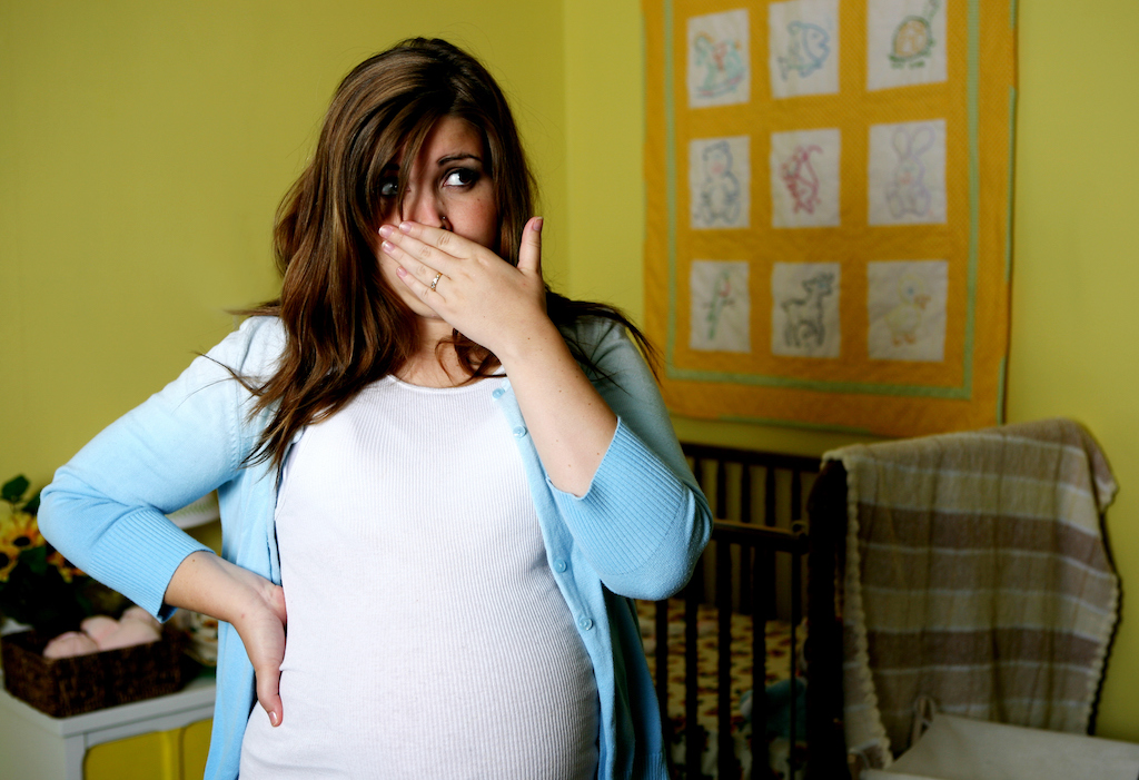 Young pregnant woman in baby room which is developing a musty smell