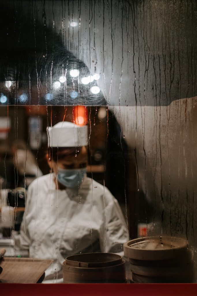 Restaurant Chef working at night behind a glass frontage with Window Condensation
